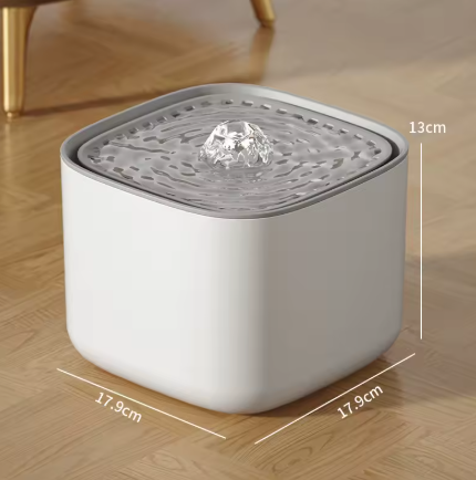 Witte AquaBuddy™ drinkfontein met stromend water en drinkende kat in moderne keuken.